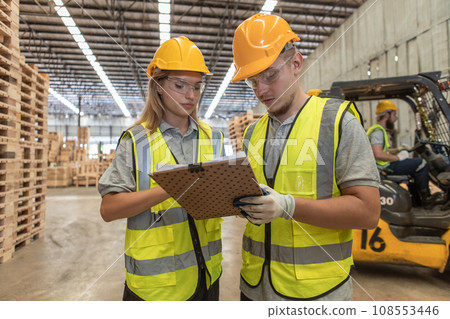 Team engineer carpenter wearing safety uniform and hard hat working holding clipboard checking Team engineer carpenter wearing safety uniform and hard hat working holding clipboard checking 108553446