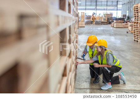 Team engineer carpenter wearing safety uniform and hard hat working holding clipboard Team engineer carpenter wearing safety uniform and hard hat working holding clipboard 108553450