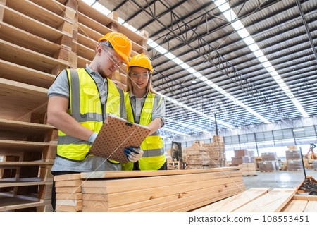 Team engineer carpenter wearing safety uniform and hard hat working holding clipboard Team engineer carpenter wearing safety uniform and hard hat working holding clipboard 108553451