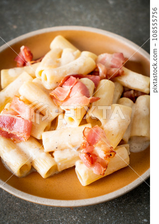 spaghetti rigatoni pasta with white sauce and bacon 108555756