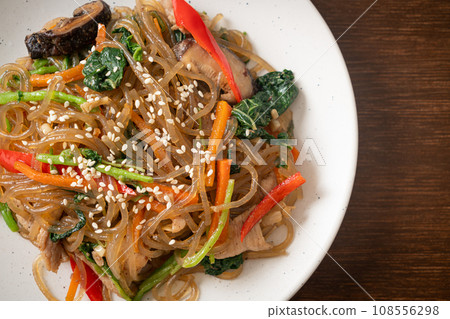 japchae or stir-fried Korean vermicelli noodles with vegetables and pork topped with white sesame 108556298