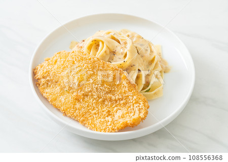 fettuccine pasta white cream sauce with fried fish 108556368