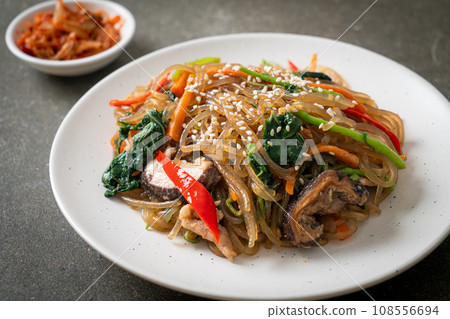 japchae or stir-fried Korean vermicelli noodles with vegetables and pork topped with white sesame 108556694