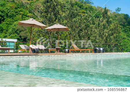 bed pool with umbrella around swimming pool bed pool with umbrella around swimming pool 108556867