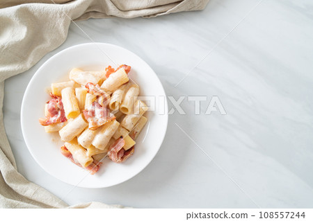 spaghetti rigatoni pasta with white sauce and bacon 108557244