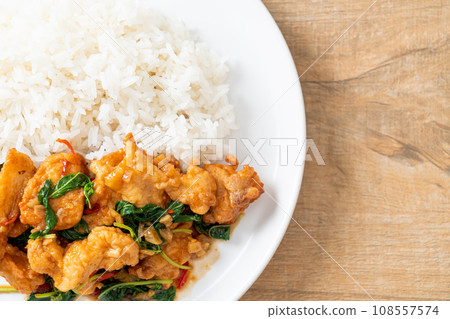 stir-fried fried fish with basil and chili in thai style topped on rice stir-fried fried fish with basil and chili in thai style topped on rice 108557574