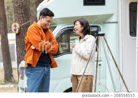 A man and a woman chatting in front of a camper A man and a woman chatting in front of a camper 108558553