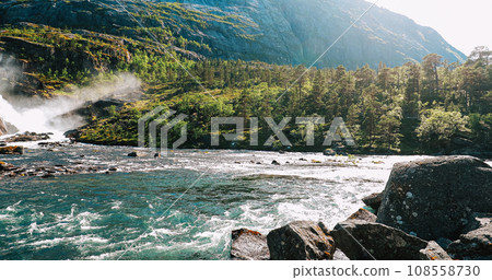 Kinsarvik, Hordaland, Norway. Waterfall Nykkjesoyfossen In Hardangervidda Mountain Plateau. Spring Sunny Day. Height Of 49 m. Famous Norwegian Landmark And Popular Destination. Panorama. Bold Colors Kinsarvik, Hordaland, Norway. Waterfall Nykkjesoyfossen In Hardangervidda Mountain Plateau. Spring Sunny Day. Height Of 49 m. Famous Norwegian Landmark And Popular Destination. Panorama. Bold Colors 108558730