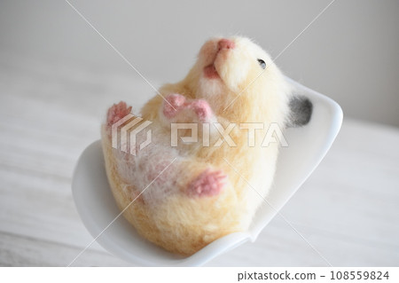 Woolly felt hamster leaning on a chair 108559824