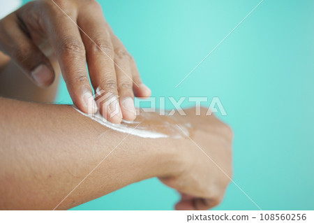 man applying beauty cream onto skin  108560256