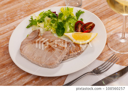 Scandinavian cuisine seafood served with greens and vegetables on plate on wooden table 108560257