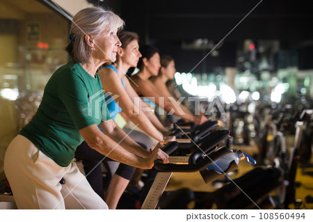 Mature woman taking cycling class at gym 108560494