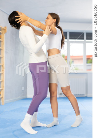 Young woman practicing painful technique to eyes in mock bout during self-defense training Young woman practicing painful technique to eyes in mock bout during self-defense training 108560550