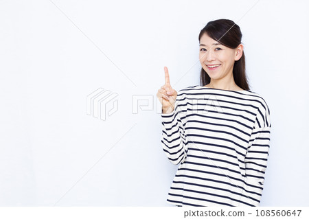 一名 40 多歲的女性在白色背景前舉起食指 一名 40 多歲的女性在白色背景前舉起食指 108560647