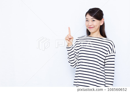 一名 40 多歲的女性在白色背景前舉起食指 108560652
