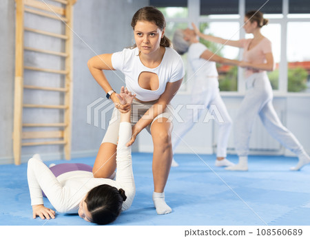 Young woman practicing painful arm hold in sparring during self defence class 108560689