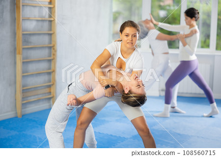Young woman practicing inverted headlock in sparring guring self-defence training 108560715