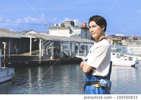 A young fisherman working at a fishing port A young fisherman working at a fishing port 108560833