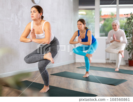Young girl standing in balancing asana Eka Pada Utkatasana Young girl standing in balancing asana Eka Pada Utkatasana 108560861
