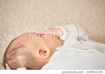 Baby trying to sleep by sucking his finger Baby trying to sleep by sucking his finger 108561209