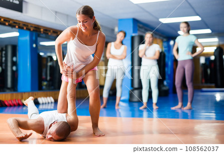 Young woman practicing self defence techniques with coach Young woman practicing self defence techniques with coach 108562037