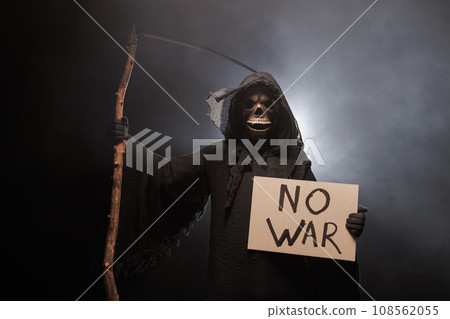 The Grim Reaper holds a poster with the inscription no war. The scary grim reaper. Death Grim Reaper The Grim Reaper holds a poster with the inscription no war. The scary grim reaper. Death Grim Reaper 108562055