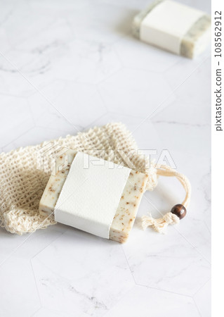 Beige handmade soap bars with blank label on soap saver bag close up, mockup 108562912