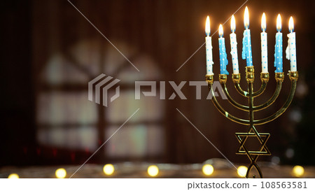 Hanukkah candlestick with book on table Hanukkah candlestick with book on table 108563581
