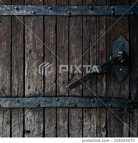 Old rotten wormy ancient oak door and metal parts, wooden textured castle door 108563670