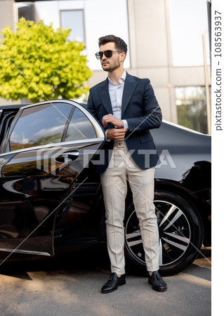 Businessman standing near luxury car Businessman standing near luxury car 108563937