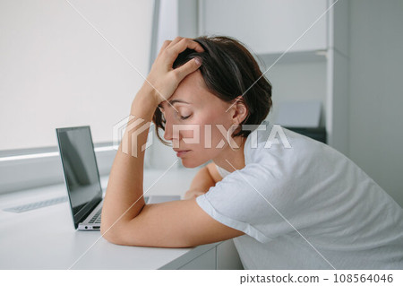 Woman sleeping on laptop keyboard. Tired, frustrated, exhausted, stressed woman sitting at desk working on laptop. Daylight work. Woman sleeping on laptop keyboard. Tired, frustrated, exhausted, stressed woman sitting at desk working on laptop. Daylight work. 108564046