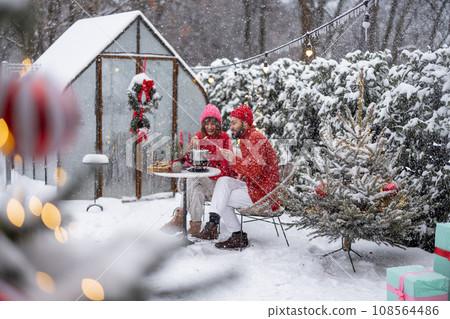 Young family have romantic dinner during winter holidays outdoors Young family have romantic dinner during winter holidays outdoors 108564486