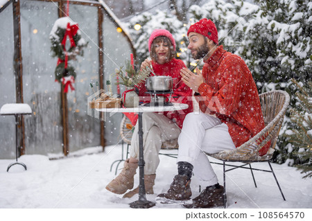 Young family have romantic dinner during winter holidays outdoors Young family have romantic dinner during winter holidays outdoors 108564570