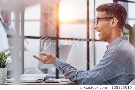 man working on a laptop at a desk, photo in profile 108565010