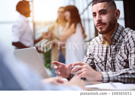 Young adult caucasian male, hiring manager, sits at a desk in a modern office 108565051