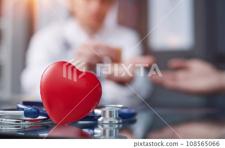 Stethoscope and red heart on wooden table. Cardiology concept 108565066