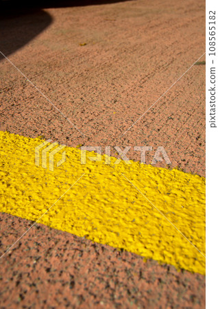 Asphalt concrete road with yellow stripes and car parking area Asphalt concrete road with yellow stripes and car parking area 108565182