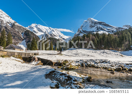 Alp with stream and view of Saentis, snowy landscape, Toggenburg, Canton St. Gallen, Switzerland 108565511