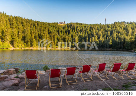 Red, empty deckchairs at Mummelsee Lake in the Black Forest Red, empty deckchairs at Mummelsee Lake in the Black Forest 108565516