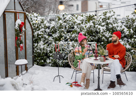 Young family have romantic dinner during winter holidays outdoors Young family have romantic dinner during winter holidays outdoors 108565610