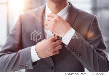 business man in a white shirt, a man straightens his tie 108565902