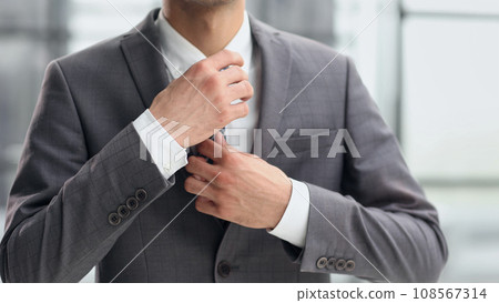 business man in a white shirt, a man straightens his tie 108567314
