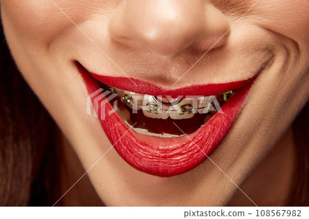 Creepy smile. Close up portrait of beautiful young girl with smiling lips. Lip matte lipstick. Skin care routine. 108567982