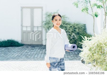 Young woman with a yoga mat 108568106