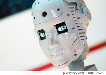 Closeup of white illuminated human robot looking camera against blurred background Closeup of white illuminated human robot looking camera against blurred background 108568525