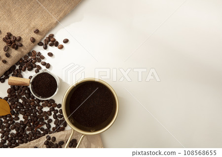 Creative minimal banner background from coffee beans. Against the white background, brown roasted coffee beans and coffee powder decorated. Empty space for design or copy space 108568655