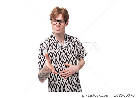 European young man with golden hair and a tattoo on his arms, dressed in a summer black and white European young man with golden hair and a tattoo on his arms, dressed in a summer black and white 108569076
