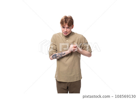 young european man with red golden hair is dressed in a light brown shirt on a white background young european man with red golden hair is dressed in a light brown shirt on a white background 108569130