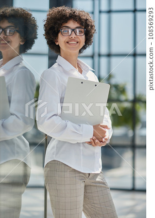 Smiling confident business leader looking at camera and standing in an office 108569293