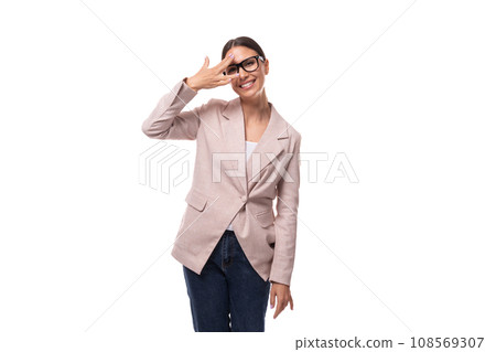 a young positive brunette with her hair gathered in a ponytail, dressed in a light jacket, smiles a young positive brunette with her hair gathered in a ponytail, dressed in a light jacket, smiles 108569307